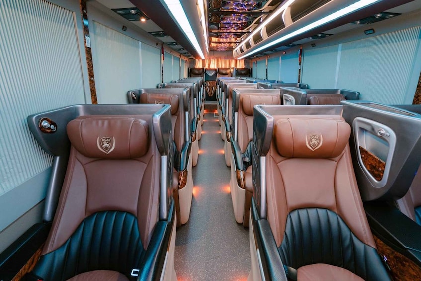 A train interior with rows of seats, each with a logo and a small table. 3