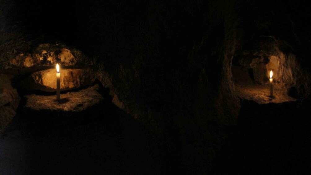 Two lit candles in a dark cave. 3