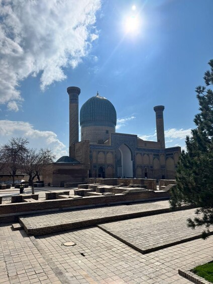 A historic building with a large dome and two minarets, surrounded by a courtyard with stone pathways. 2