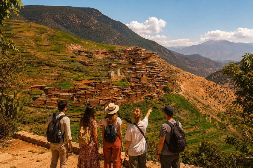 A group of people observing a terraced village with traditional architecture. 4
