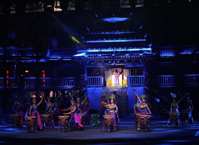 A stage performance with actors in traditional costumes, a backdrop of a traditional building, and a spotlight effect. 2