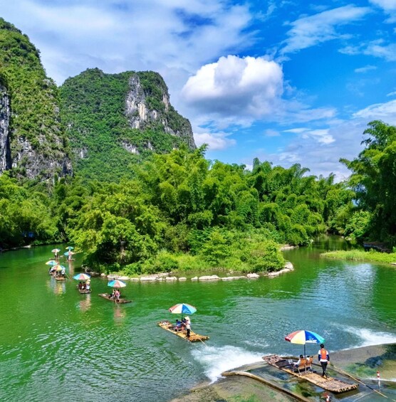 People on a river in a forested area with boats and umbrellas. 1