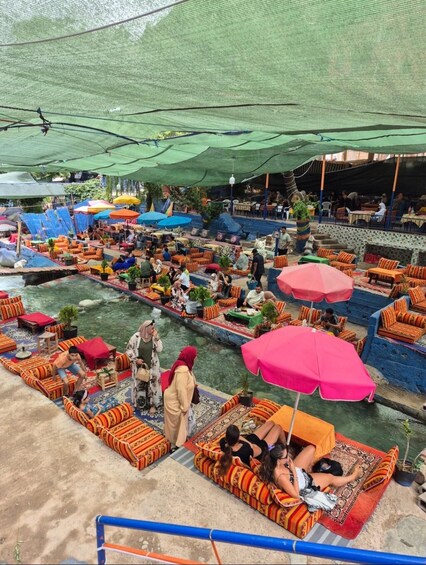 A riverside outdoor seating area with colorful cushions and umbrellas. 2