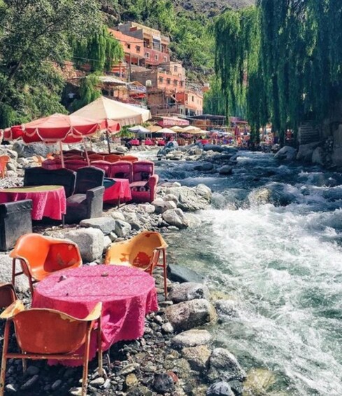 Outdoor seating by a river with rocks and a flowing stream. 1