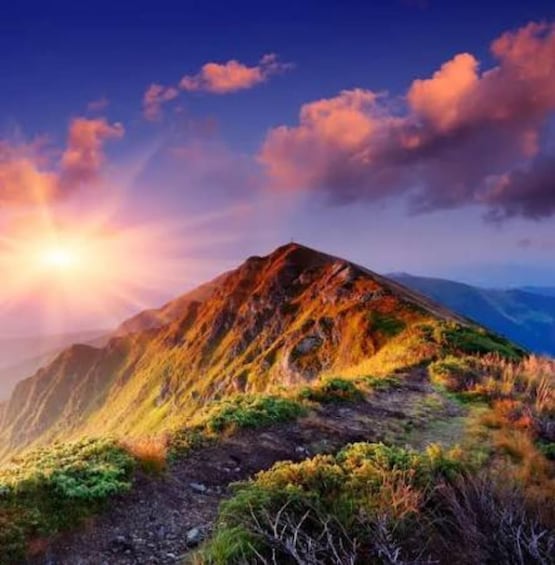 A mountain with a sunrise or sunset, casting warm colors on the slopes. 5