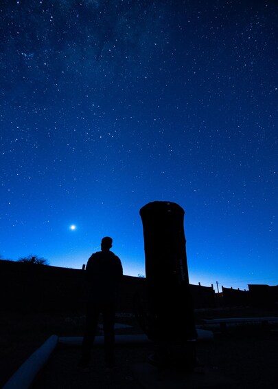 Una persona de pie bajo un cielo estrellado, mirando hacia las estrellas. 4
