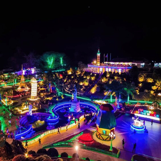 A brightly lit amusement park with roller coasters and a Ferris wheel. 3