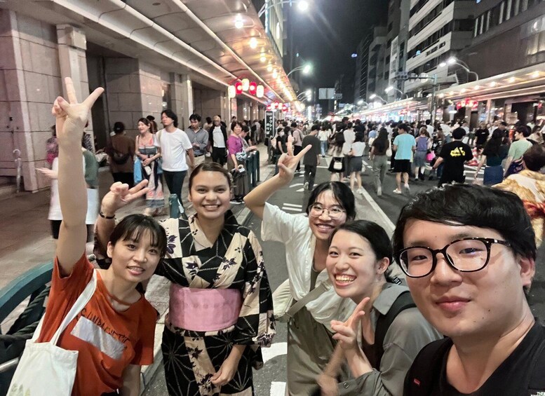 A crowded street at night with people walking and taking photos. 2