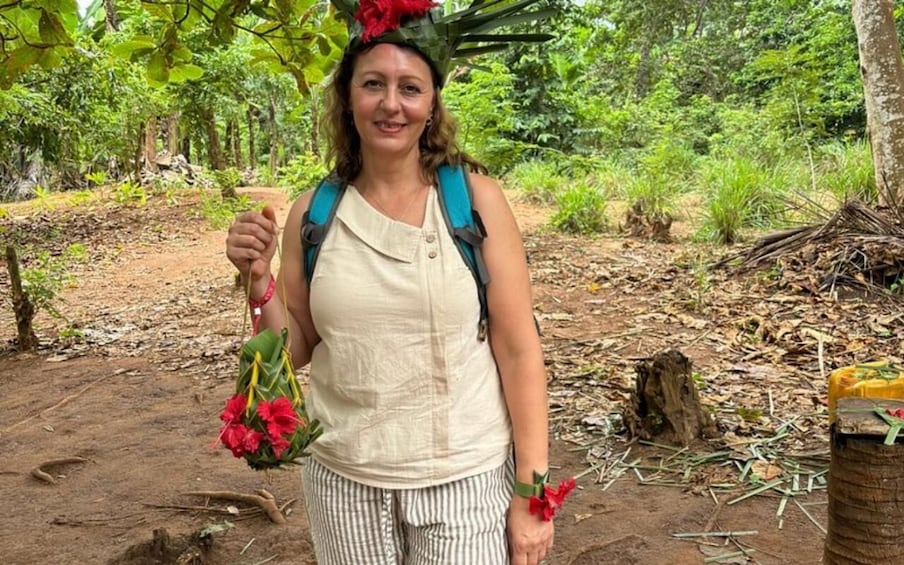 A person in a forest holding a bouquet of red flowers. 5
