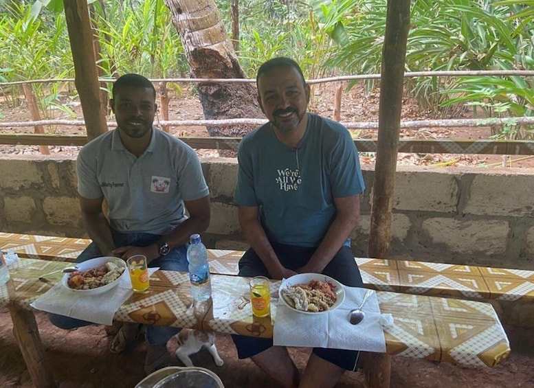 Two men sitting at a table with food and drinks. 4