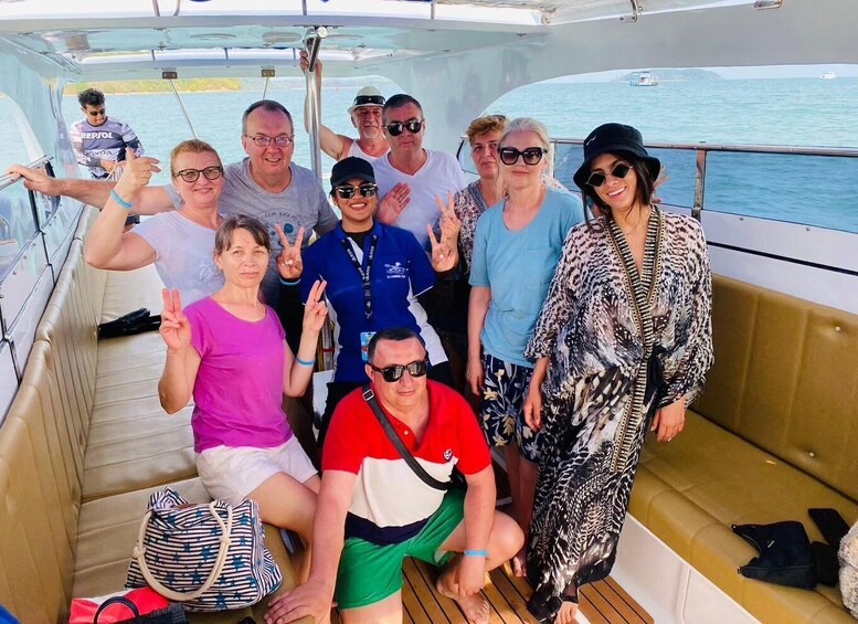 A group of people on a boat with a water body in the background. 5