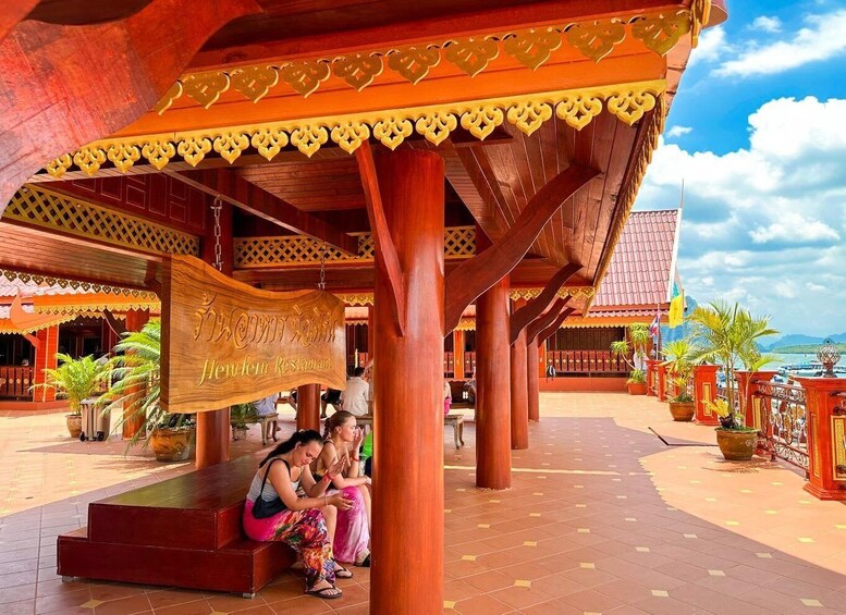 A traditional wooden structure with a sign reading "Newlen Restaurant" and people sitting on a bench. 3