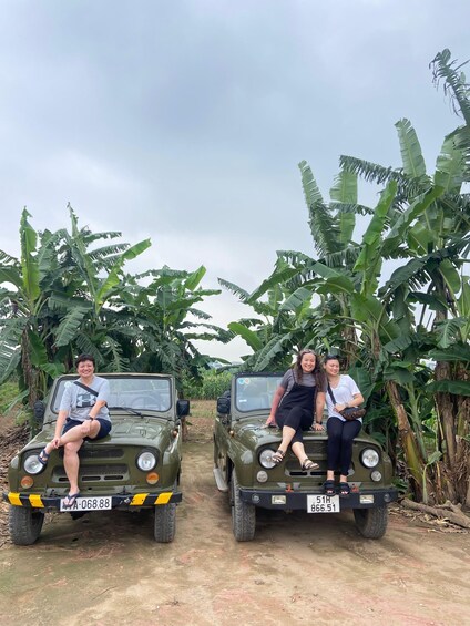 Two military-style jeeps parked in a banana plantation. 1