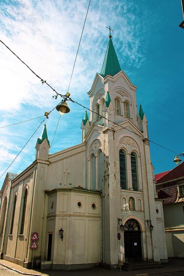 A church with a green spire and arched windows. 4