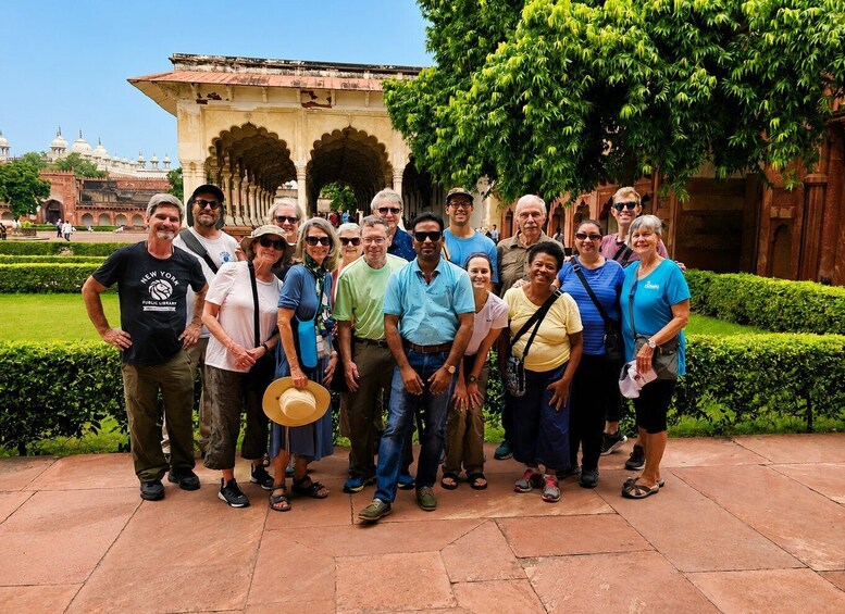 A group of people standing in a courtyard with a building in the background. 3