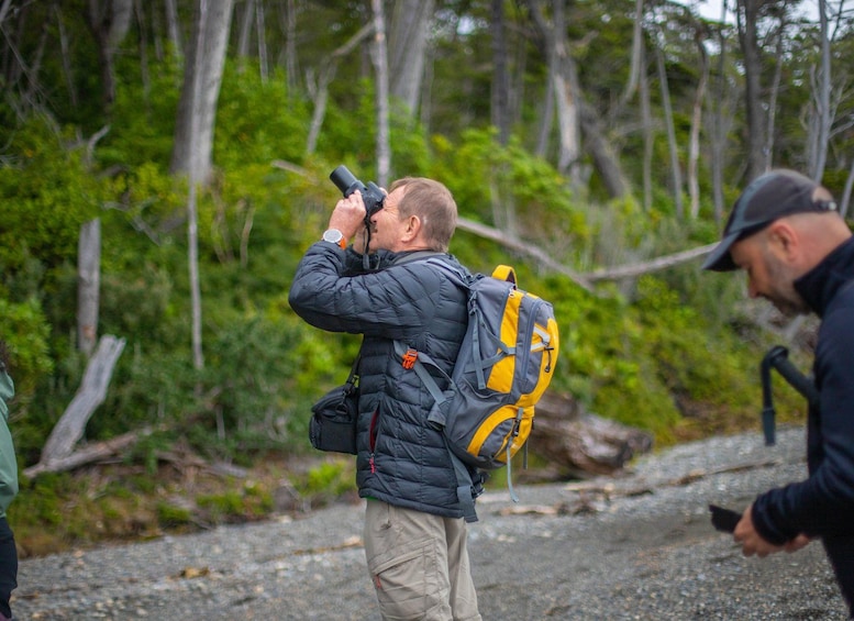A person taking a photograph with a camera, wearing a jacket and carrying a backpack. 2