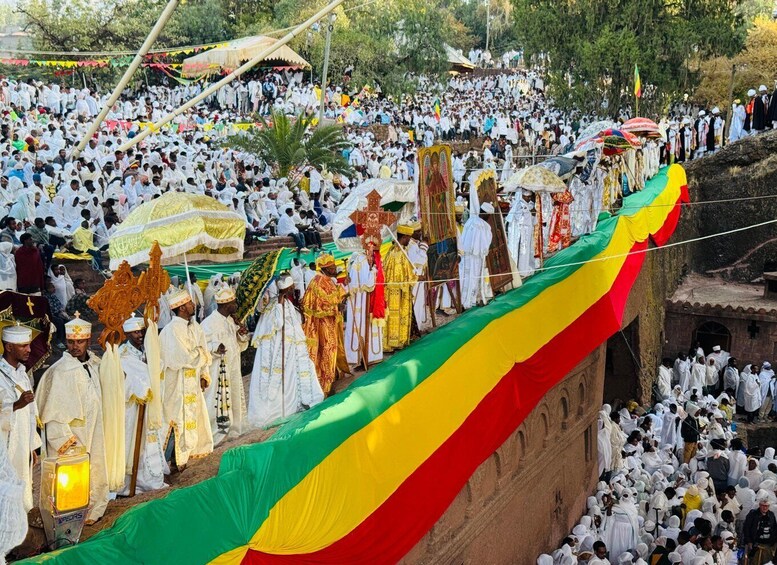 A large crowd gathered for a procession with a colorful banner. 5