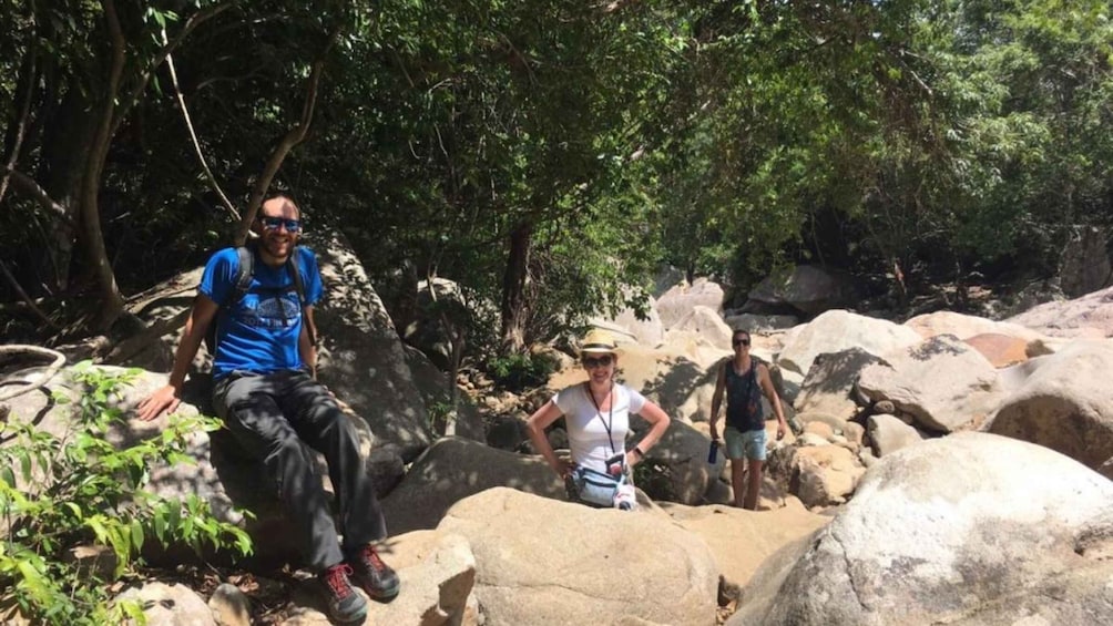 People hiking on a rocky trail surrounded by trees. 4