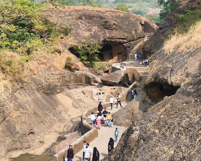 A group of people walking on a stone staircase in a rocky landscape. 1