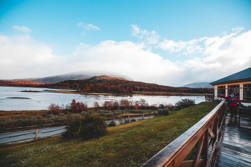 A wooden bridge over a river with autumn foliage and distant mountains. 3