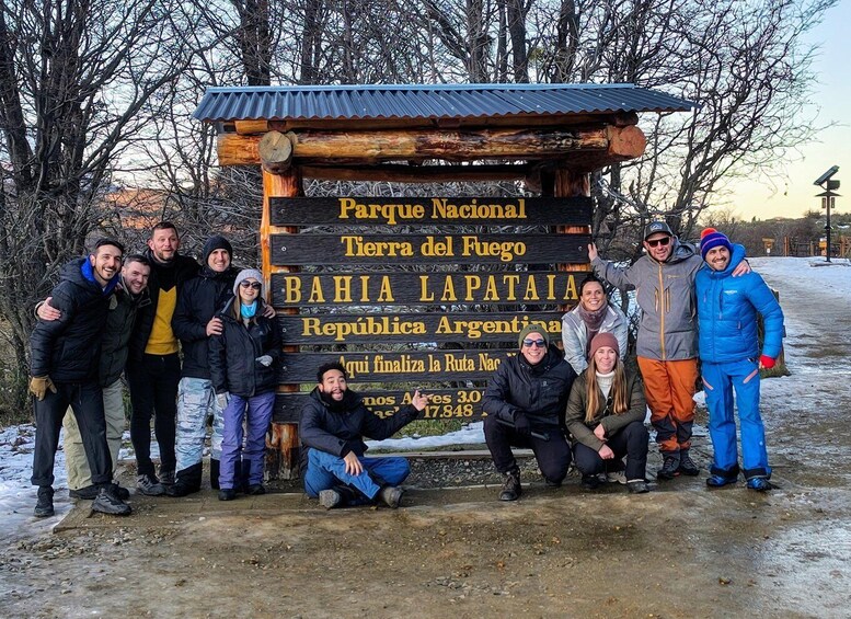 A group of people posing in front of a wooden sign with text in Spanish. 4