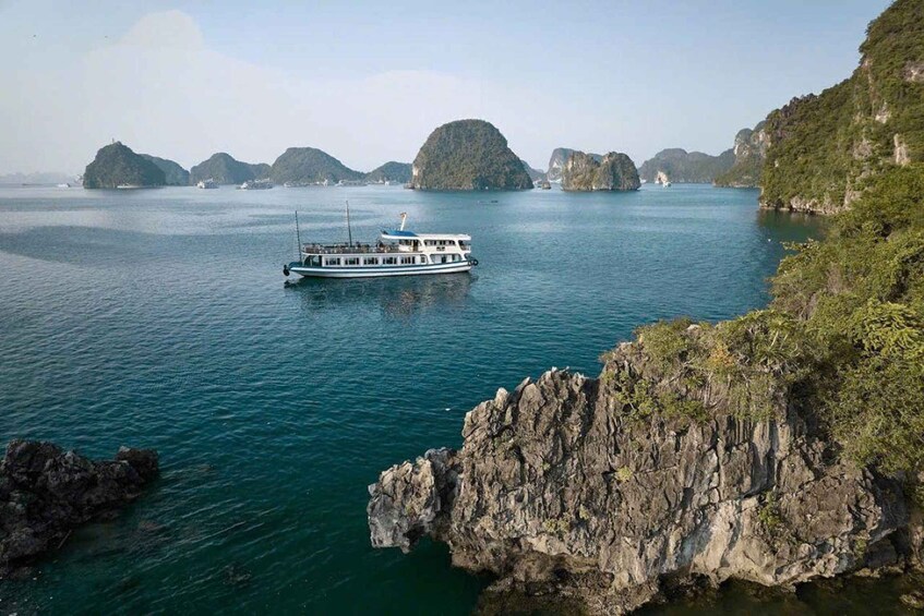 A boat on a calm sea with rocky islands in the background. 1