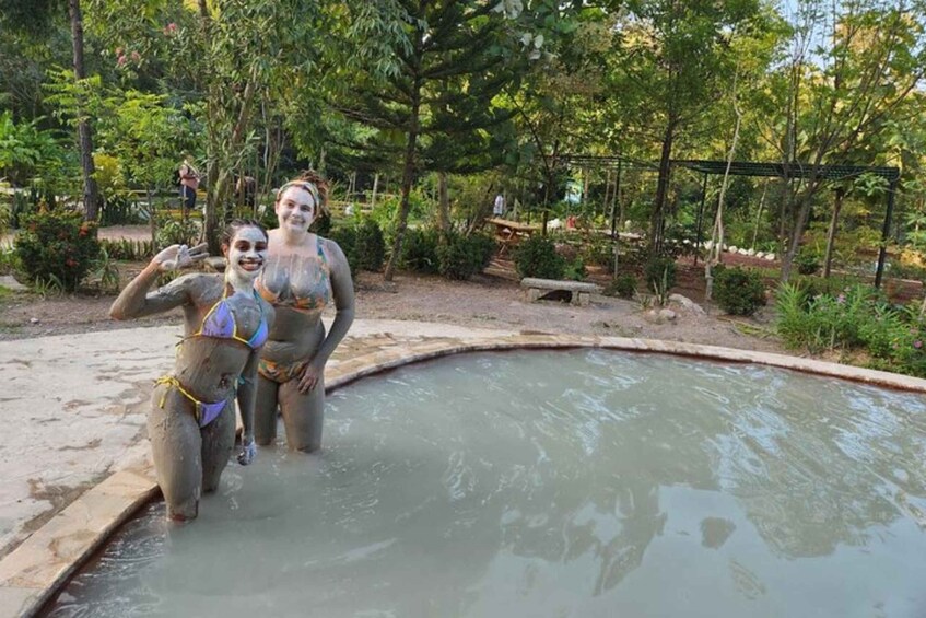 Two people in a natural setting with a pool and greenery. 3