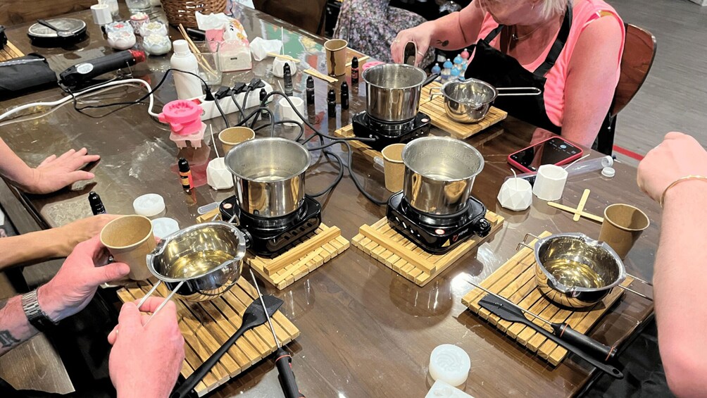 People cooking with multiple portable stoves on wooden boards. 5
