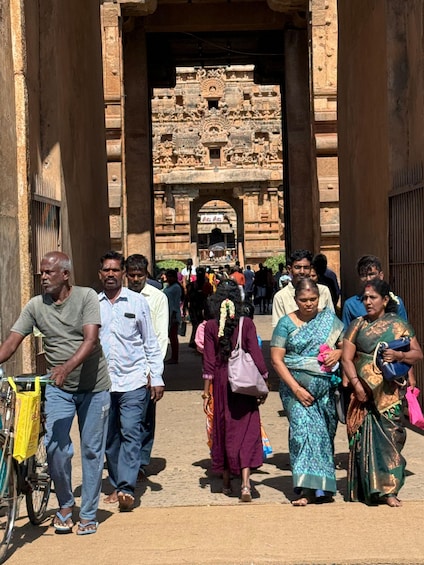 A group of people walking towards a stone gateway with intricate carvings. 3