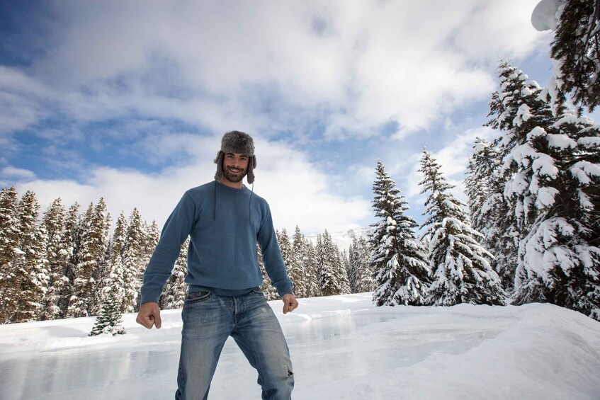 A person standing on a snow-covered slope with snow-laden trees in the background. 5