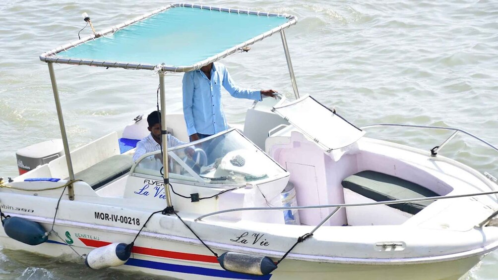 A small motorboat named 'La Vie' with a canopy, on calm water. 1