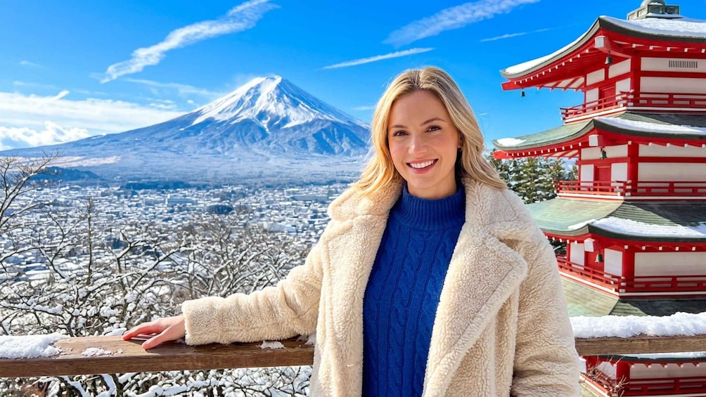 A person in a snowy landscape with a mountain and traditional red architecture. 5