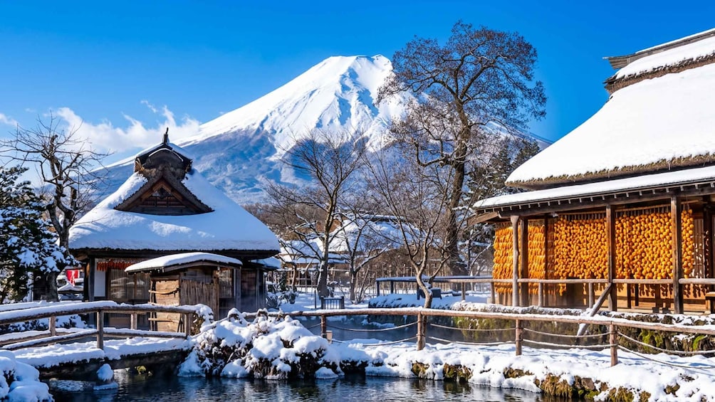 A snowy landscape with traditional buildings, a mountain in the background, and a frozen river. 3