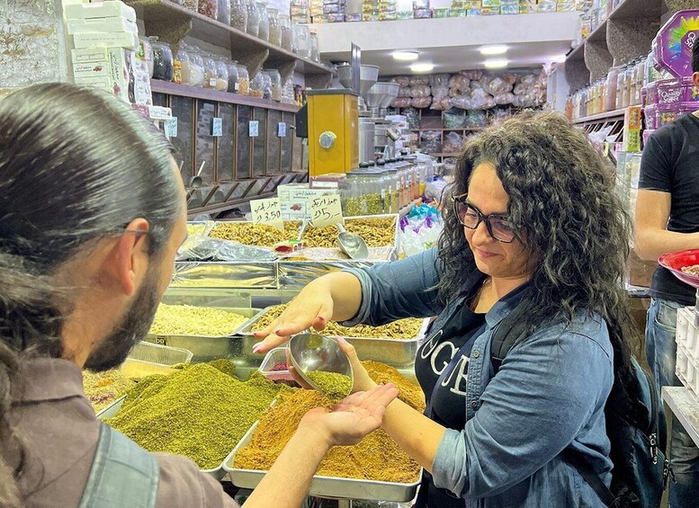 A person selecting spices from a market display. 1
