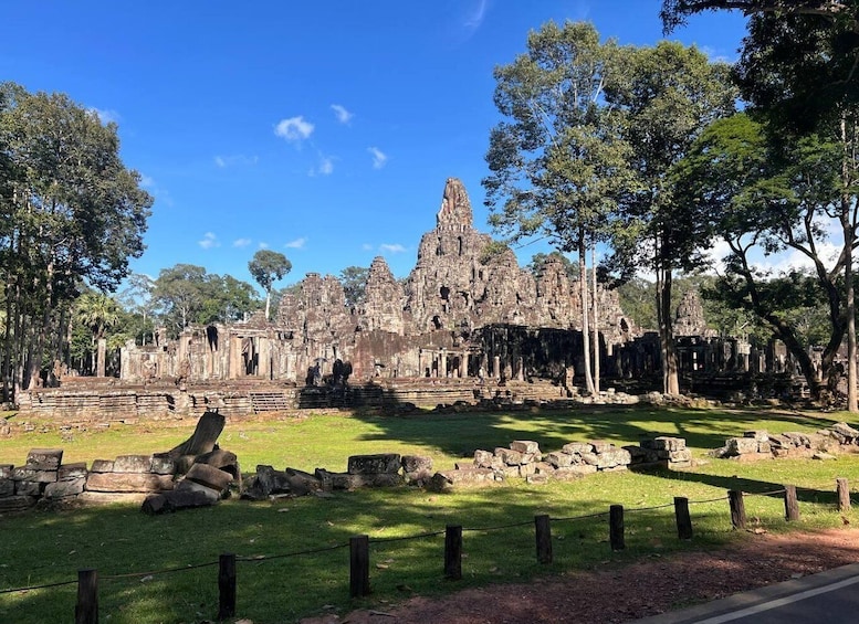Ancient stone ruins with a prominent central tower, surrounded by trees and grassy areas. 2