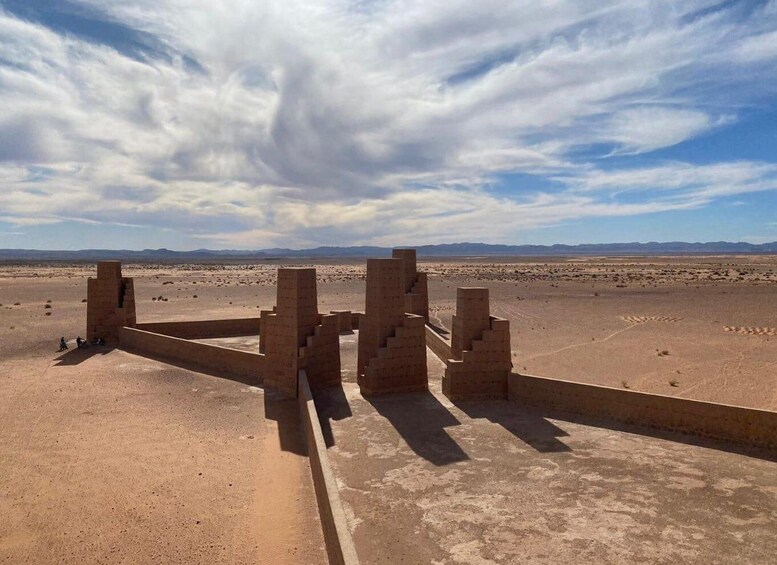 Ancient ruins in a desert landscape with distant mountains. 1