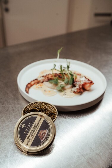 A plate of food with a can of Osieira Caviar on a table. 4