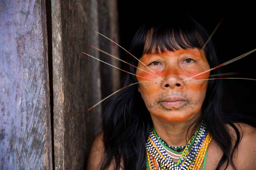 A person with long black hair and a colorful beaded necklace. 5