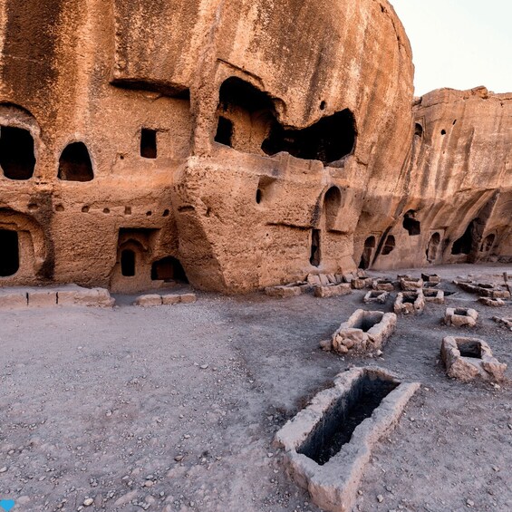 Ancient rock-cut architecture with multiple cave-like structures and rectangular stone platforms. 3