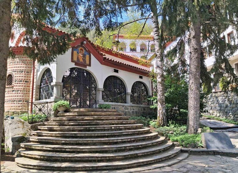 A church with a red roof, arched windows, and a staircase leading to its entrance. 5