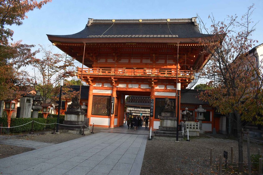 A traditional Japanese gate with a curved roof, surrounded by trees and stone lanterns. 3