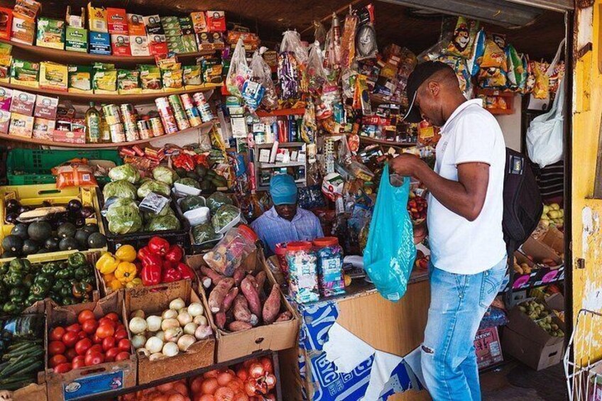 Un puesto de mercado con diferentes verduras y productos envasados. 3