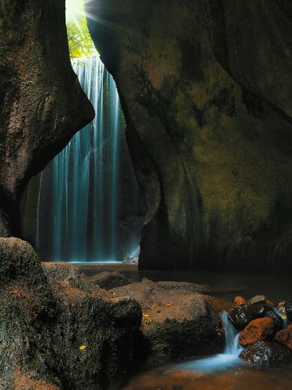 A waterfall cascading through a rocky cave entrance. 3
