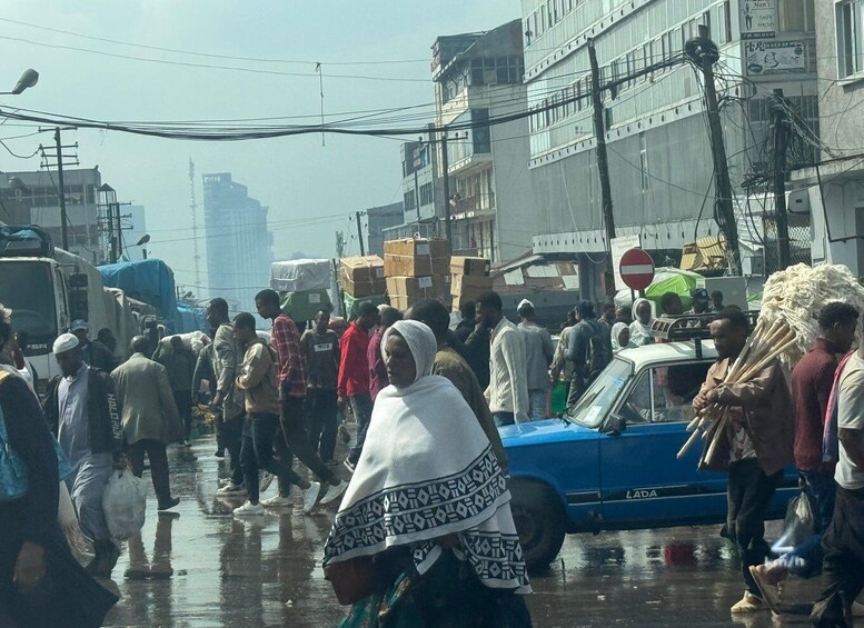 A crowded street with pedestrians, vehicles, and buildings. 5