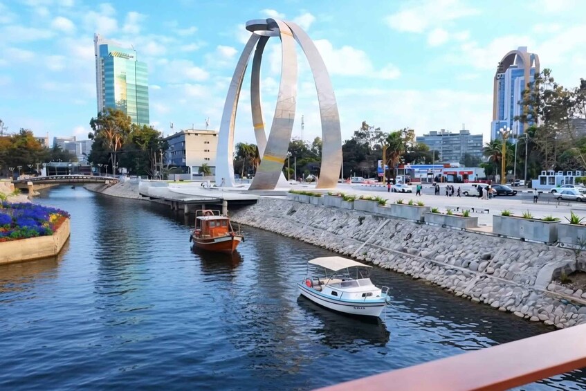 A canal with boats, a modern bridge, and city buildings. 1