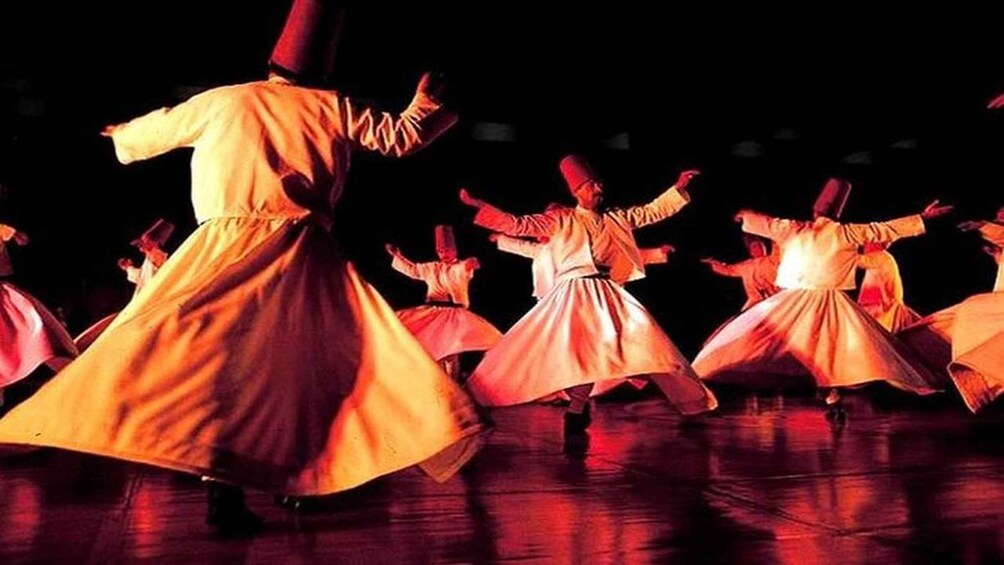 A group of dancers in traditional costumes performing on a stage. 5
