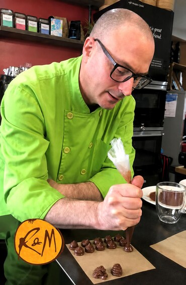 A person in a green chef's coat preparing food. 5