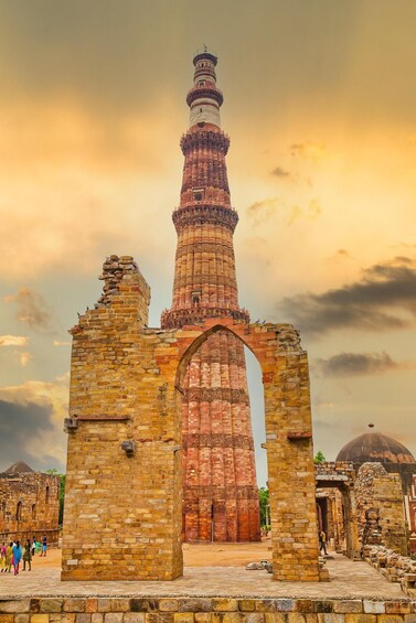 A historic tower with intricate carvings, set against a sunset sky. 4