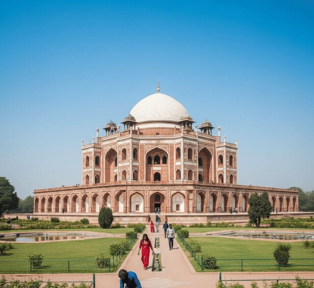 A large, historic building with a central dome and multiple minarets, surrounded by a well-maintained garden and a clear sky. 2