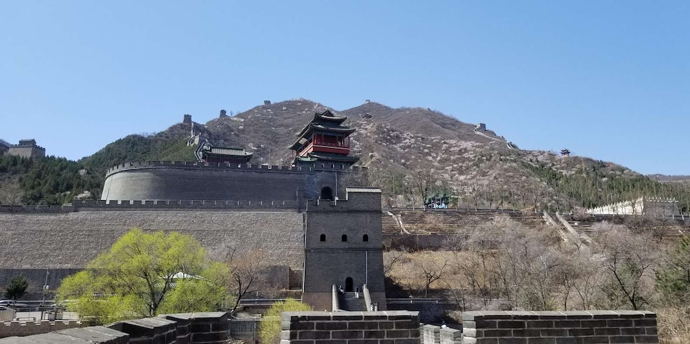 A traditional Chinese fortification with a watchtower and a pagoda, set against a backdrop of a mountainous landscape. 4